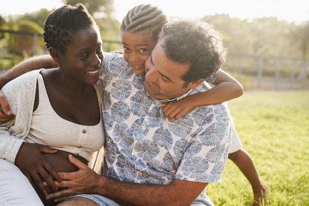 Família multirracial tendo um momento de ternura fazendo piquenique ao ar livre no parque da cidade Foco no cabelo do pai