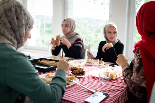 Familia musulmana y amigos reunidos en casa para cenar. foto de alta calidad