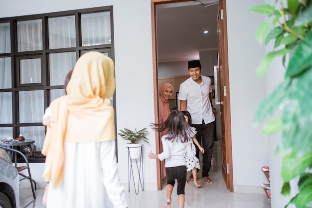 Familia musulmana asiática emocionada visitando amigo durante eid fitri mubarak en casa