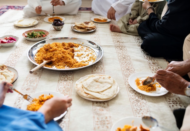 Familia musulmana cenando en el piso