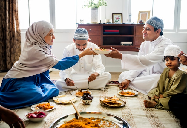 Foto familia musulmana cenando en el suelo.