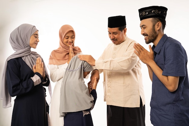 Familia musulmana da la mano en la celebración de idul fitri