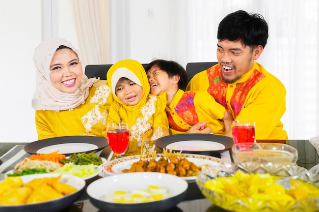 La familia musulmana se ríe juntos mientras rompen el ayuno