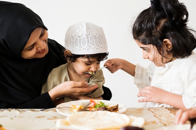 Familia musulmana teniendo una comida