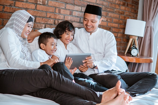 Familia musulmana usando tableta juntos
