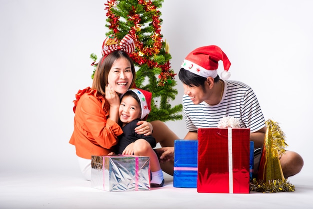 Familia muy feliz con regalo al día Navidad y feliz año nuevo en el fondo en el estudio