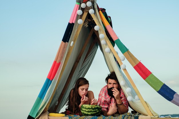 Família na barraca Casal apaixonado comendo no acampamento Homem fumando com mulher no piquenique ao ar livre