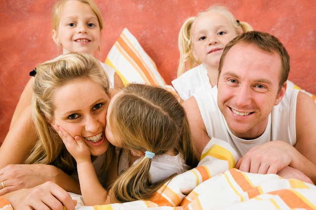 Família na cama, um beijinho