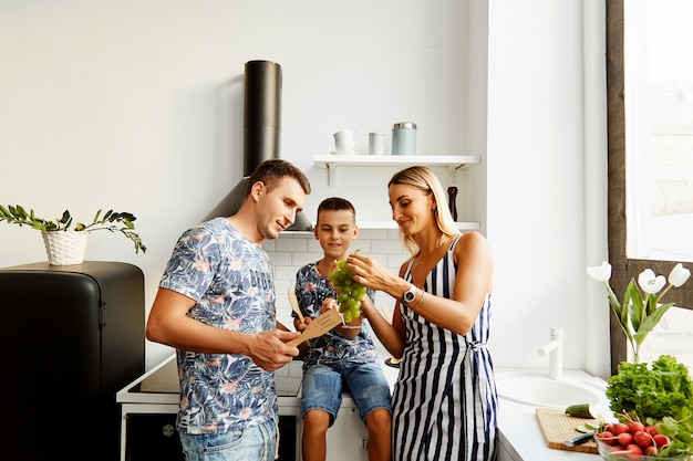 Família na cozinha comendo uvas