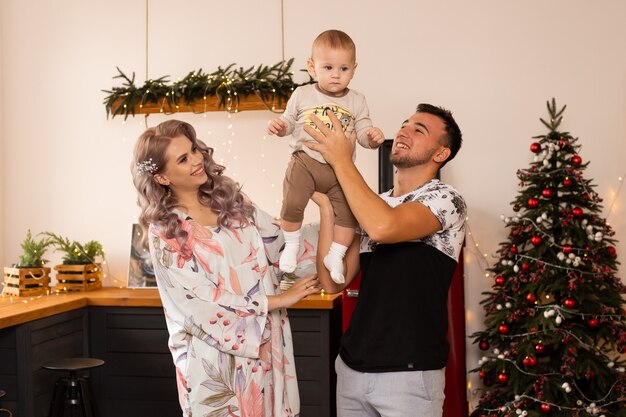 Família na cozinha perto da árvore de natal bem decorada, curtindo a magia do natal.