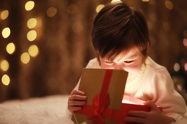 Família na véspera de Natal na lareira Crianças abrindo presentes de Natal Crianças debaixo da árvore de Natal com caixas de presente Sala de estar decorada com lareira tradicional Aconchegante noite de inverno quente em casa