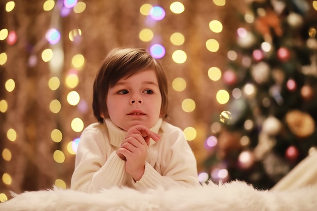 Família na véspera de Natal na lareira. Crianças abrindo presentes de Natal. Crianças debaixo da árvore de Natal com caixas de presente. Sala decorada com lareira tradicional. Aconchegante noite quente de inverno em casa.