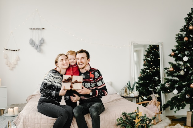 Foto familia de navidad abrazando familia abierta presente caja de regalo feliz navidad y felices fiestas