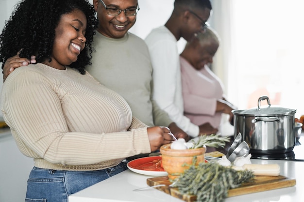 Familia negra feliz cocinando dentro de la cocina en casa Centrarse en la cara de la hija