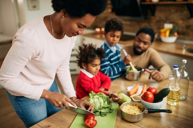Família negra feliz preparando uma refeição saudável na cozinha