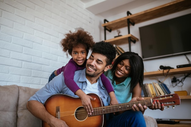 Una familia negra feliz tocando y cantando canciones juntos.