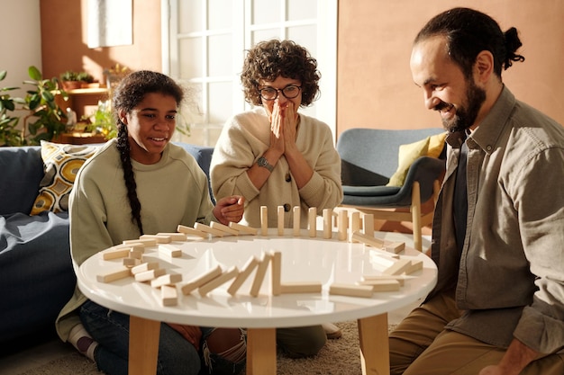 Foto familia con niño adoptado jugando al juego de mesa