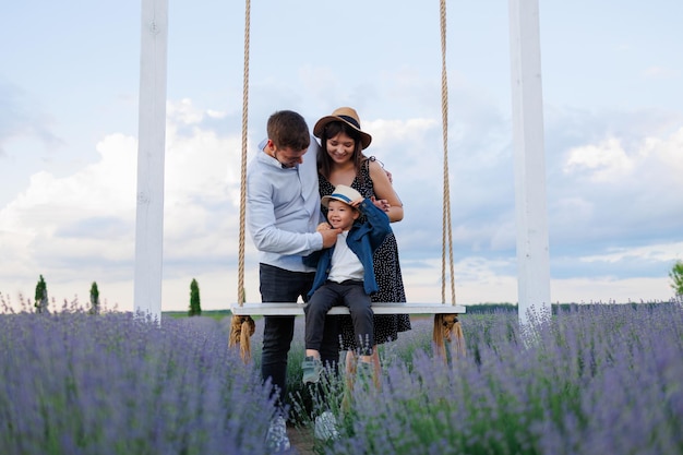 Familia con un niño en un columpio en un campo de lavanda