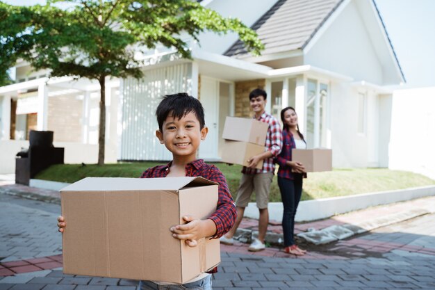 Familia con niño parado frente a su casa