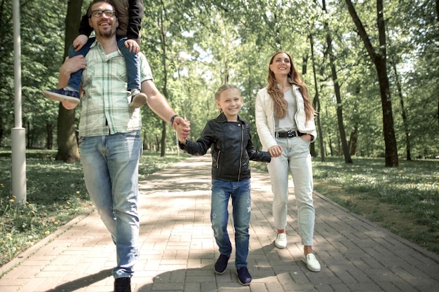 Foto familia con niños caminando por el sendero de la ciudad parkphoto con espacio para copiar