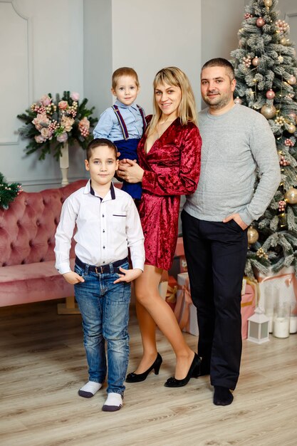 Familia con niños cerca del árbol de Navidad