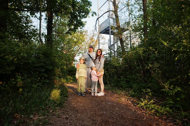 Familia con niños contra la torre de observación en la Atalaya de la República Checa de Brno durante la puesta de sol con árboles