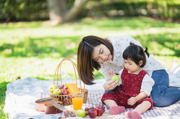 Familia con niños disfrutando de un picnic en el jardín de primavera