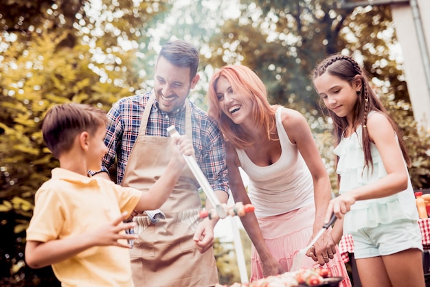 Familia con niños hacen barbacoa