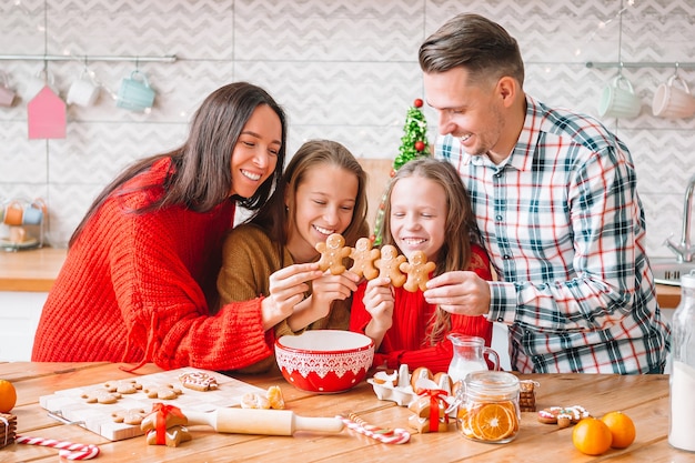 Familia con niños con pan de jengibre en Navidad en la cocina. Feliz Navidad y Felices Fiestas.