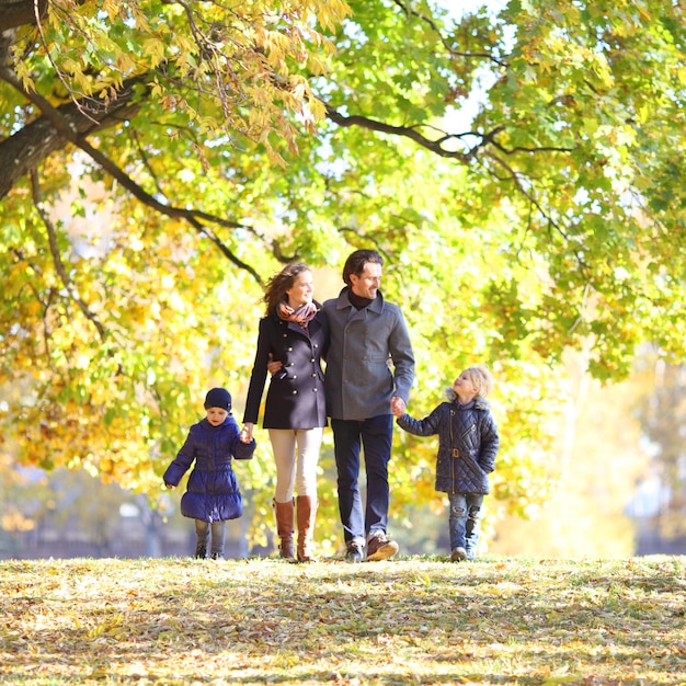 Familia con niños en el parque de otoño