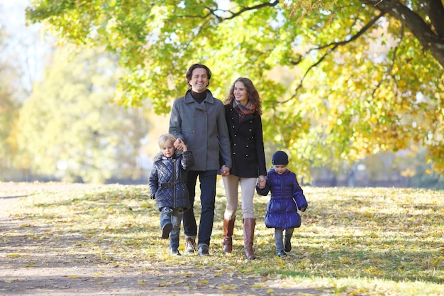 Familia con niños en el parque de otoño