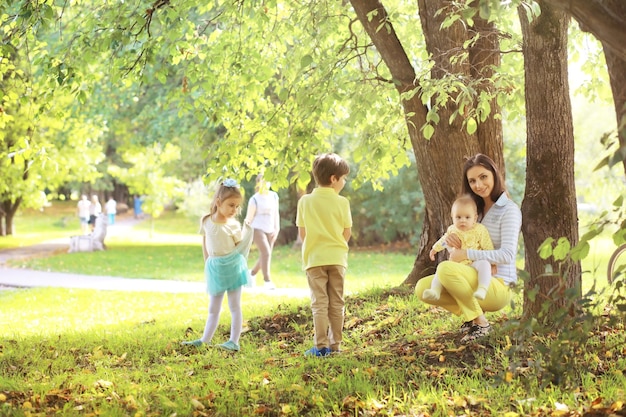 Foto familia con niños a pasear por el parque de verano. сoming otoño en el parque. familia. otoño. felicidad.