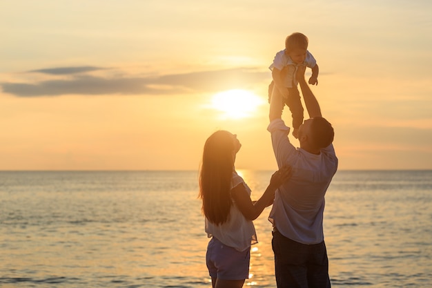 Família no conceito de praia, pai jogando e carregando seu filho na praia tropical