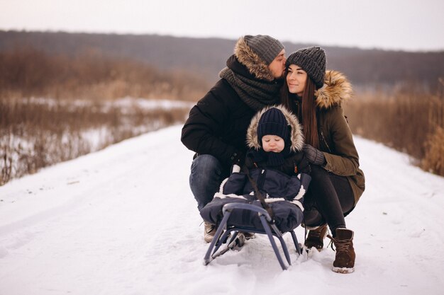 Família no inverno com trenó de filho