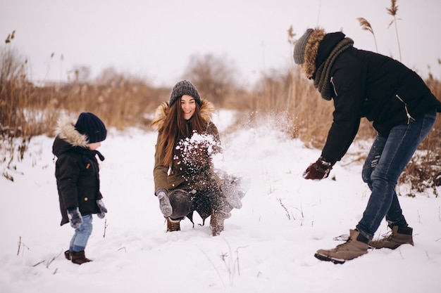 Família no inverno jogando com neve no parque