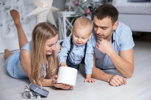 Família no Natal com presentes Mãe pai e bebê na árvore de Natal Feriados de ano novo