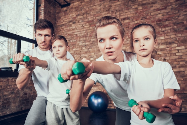 Foto família nova que faz exercícios com dumbbells.