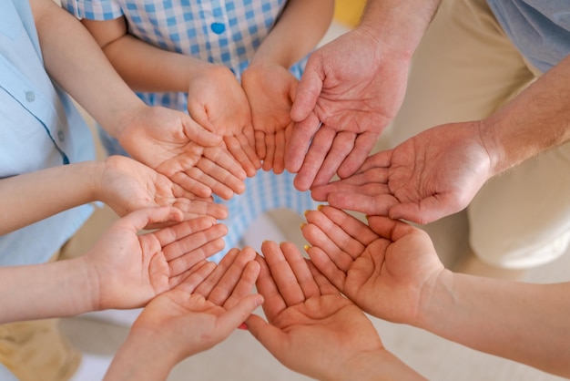 La familia numerosa sostiene las palmas de las manos juntas concepto felicidad en la familia y asistencia mutua