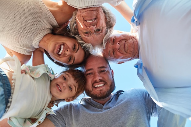 Família o centro da vida Retrato de baixo ângulo de uma família feliz de três gerações reunida ao ar livre