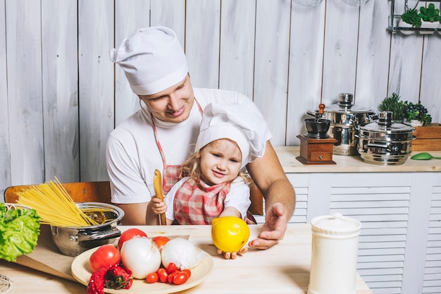 Familia, papá hija hermosa en casa la cocina riendo y preparando comida juntos