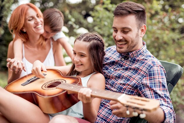 Familia en un parque divirtiéndose tocando música