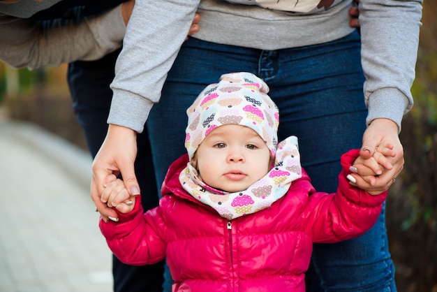 La familia en el parque. Felices padres con niños a pie