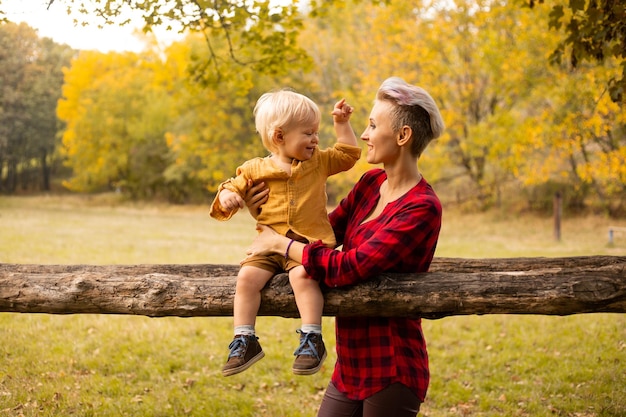 Familia en el parque de otoño Mamá jugando con su hijo en verano