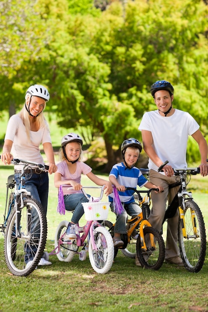 Foto familia en el parque con sus bicicletas