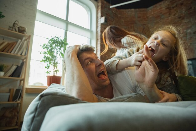 La familia pasa un buen rato juntos en casa, se ve feliz y alegre, acostados juntos