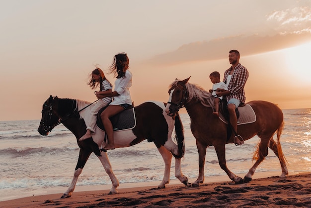 La familia pasa tiempo con sus hijos mientras montan a caballo juntos en una playa de arena. Enfoque selectivo. foto de alta calidad