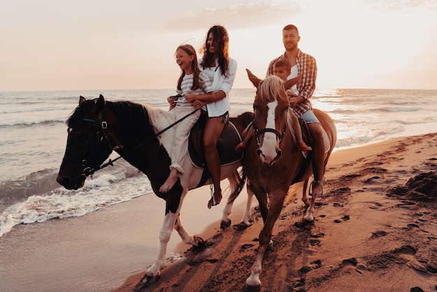 La familia pasa tiempo con sus hijos mientras montan a caballo juntos en una playa de arena. Enfoque selectivo. foto de alta calidad