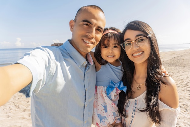 Familia pasando un buen rato en la playa juntos tomando selfie.