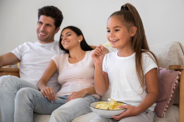 Foto familia pasando tiempo frente a la televisión