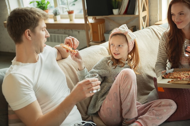 Familia pasar un buen rato juntos en casa se ve feliz y alegre mamá, papá e hija